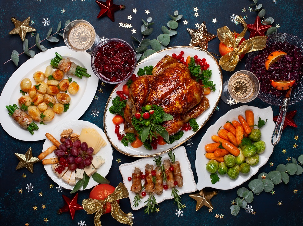 Concept of Christmas or New Year dinner with roasted chicken and various vegetables dishes.