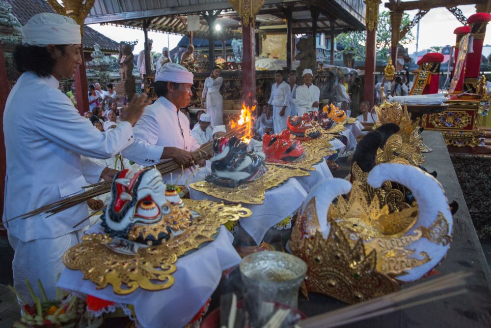 Holy text is written on a sacred balinese mask by a priest - Photo by IB Putra Adnyana